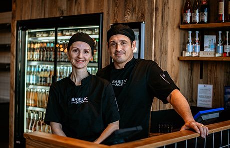 Photo de Fabien et Pauline Flouriot, multi franchisé Basilic & Co. Ils sont l'un à côté de l'autre derrière le comptoir de leur restaurant de Cholet.